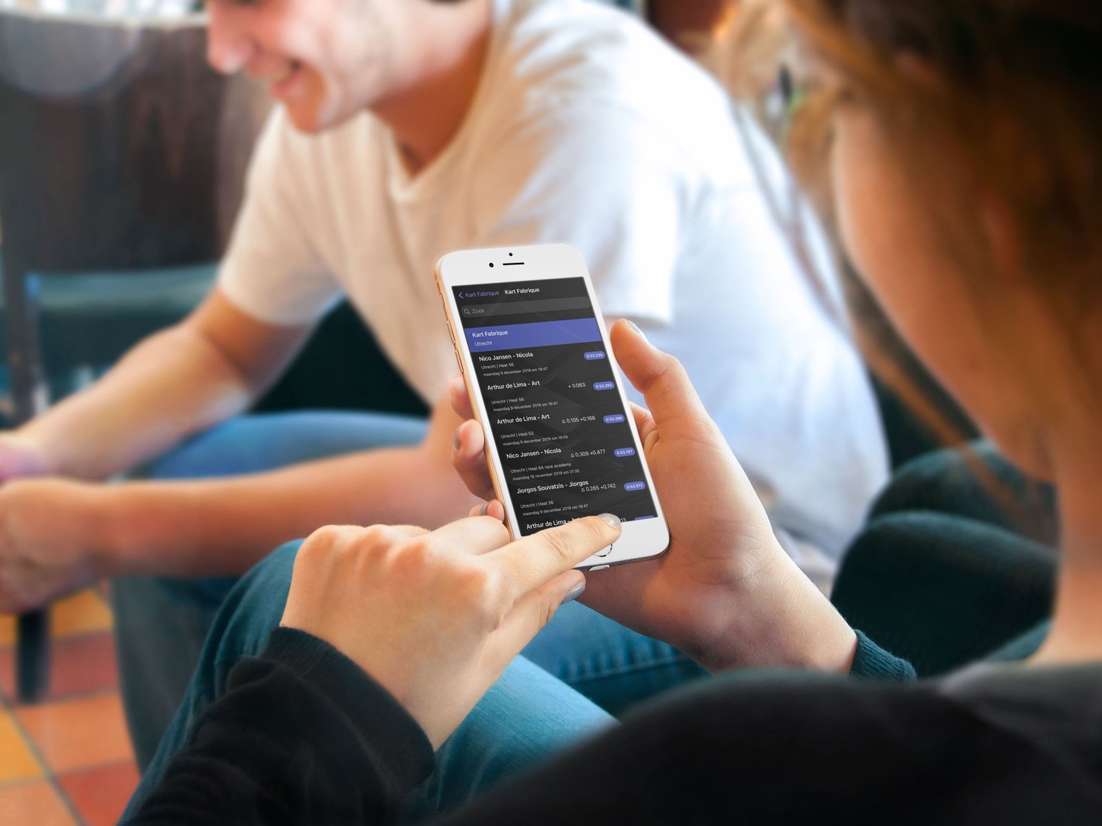 Maxify app on iPhone shown between two friends, comparing race results from a karting session