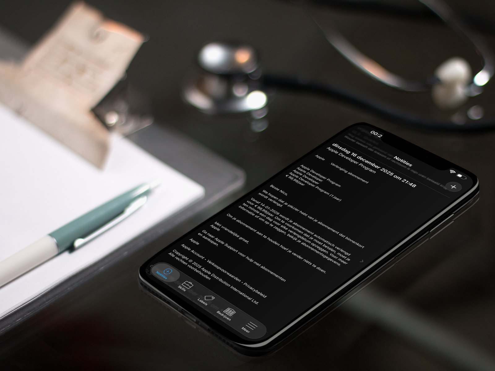 pTouch CRM app on iPhone lying on a wooden desk with a stethoscope and clipboard, showing detailed contact notes from a meeting